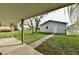 Backyard showcasing detached garage and a concrete patio, bordered by a lush green lawn at 831 N 12Th St, Elwood, IN 46036