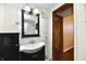 Cozy bathroom featuring a black vanity with sink, medicine cabinet and a shower with curtain, and a glimpse of the hallway at 831 N 12Th St, Elwood, IN 46036