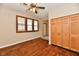 Spacious bedroom featuring hardwood floors, a ceiling fan, closet, and multiple windows at 831 N 12Th St, Elwood, IN 46036