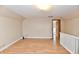 A sunny room with wood floors, featuring access to another room with a white railing and a door for an open feel at 831 N 12Th St, Elwood, IN 46036