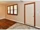 A view of the entryway with wood-look floors, a light-colored rug, and a window with wood trim at 831 N 12Th St, Elwood, IN 46036