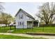 Charming two-story home featuring a fenced yard, covered porch, and traditional architecture with red shutters at 831 N 12Th St, Elwood, IN 46036