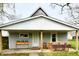 Digitally staged front of single-story home with covered porch and patio dining set at 831 N 12Th St, Elwood, IN 46036