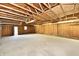 Spacious garage with concrete floor, wood-paneled walls, exposed rafters and fluorescent lighting at 831 N 12Th St, Elwood, IN 46036