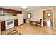 Traditional kitchen with white appliances, dark cabinets, a table with chairs and wooden flooring at 831 N 12Th St, Elwood, IN 46036