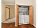 A laundry closet features wooden bi-fold doors, white appliances and shelves for linens at 831 N 12Th St, Elwood, IN 46036