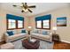 Virtual staged living room with hardwood floors, sofas, and a coffee table on a decorative rug at 831 N 12Th St, Elwood, IN 46036