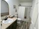 Cozy bathroom with green vanity, framed mirrors, and a shower with a linen curtain at 8333 Sansa St, Indianapolis, IN 46113