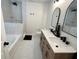 Modern bathroom featuring double vanities, and a bathtub-shower with stylish tiling at 8333 Sansa St, Indianapolis, IN 46113