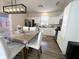 Bright kitchen with white cabinets, stainless appliances, wood floors, and modern lighting above the dining table at 8333 Sansa St, Indianapolis, IN 46113