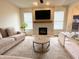 Cozy living room featuring a stone fireplace, large windows, and comfortable neutral-toned seating at 8333 Sansa St, Indianapolis, IN 46113