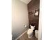 Modern powder room featuring a wood-look accent wall and minimalist decor at 8333 Sansa St, Indianapolis, IN 46113