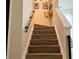 Stairway featuring hardwood stairs, white trim, and black handrails, offering a modern and clean aesthetic at 8333 Sansa St, Indianapolis, IN 46113