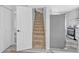 Staircase leading to kitchen boasts stainless steel appliances and white cabinetry at 835 N Dearborn St, Indianapolis, IN 46201