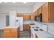 Well-lit kitchen features wooden cabinets, white appliances, and island for cooking at 84 Beech Ct, Whiteland, IN 46184