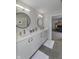 Modern bathroom with double sinks, vanity, and a round mirror at 8740 Morgan Dr, Fishers, IN 46038