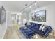 Bright living room with hardwood floors, a plush blue velvet sofa, and stylish modern art at 8740 Morgan Dr, Fishers, IN 46038