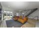 Bright living room with large windows, a modern staircase, and seamless flow into the dining area at 8740 Morgan Dr, Fishers, IN 46038