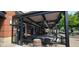 Covered outdoor patio dining area with metal structure, brick walls, and string lights for a comfortable dining experience at 8740 Morgan Dr, Fishers, IN 46038