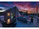 Open-air roof deck with comfortable seating, dining table, and string lights creating an inviting outdoor space at 8740 Morgan Dr, Fishers, IN 46038