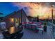 Relaxing rooftop deck with sunset views, string lights, comfortable seating, and an outdoor dining area at 8740 Morgan Dr, Fishers, IN 46038