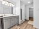 Bright bathroom with a double vanity, modern fixtures, and wood-look flooring at 8813 Browns Valley Ln, Indianapolis, IN 46113
