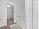 Bathroom featuring a soaking tub with white tile surround and view to a walk-in closet at 8813 Browns Valley Ln, Indianapolis, IN 46113