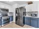 Modern kitchen with stainless appliances, two-tone cabinets, and tile flooring at 8813 Browns Valley Ln, Indianapolis, IN 46113
