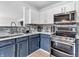 Close-up of a kitchen featuring modern appliances, two-tone cabinets, and stylish backsplash at 8813 Browns Valley Ln, Indianapolis, IN 46113