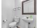 Stylish powder room with a pedestal sink and framed mirror, perfect for guests at 8813 Browns Valley Ln, Indianapolis, IN 46113