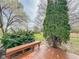 Wooden deck overlooking backyard with a bench seat and view of the lawn and mature trees at 9362 Helmsdale Dr, Indianapolis, IN 46256