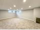 Finished basement featuring neutral carpet, gray walls, recessed lighting, and egress windows at 9362 Helmsdale Dr, Indianapolis, IN 46256