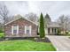 Traditional brick home with a well-manicured lawn and green shrubbery surrounding the house at 9362 Helmsdale Dr, Indianapolis, IN 46256