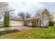 Charming light blue home featuring an attached garage, and an inviting front yard with some trees at 9362 Helmsdale Dr, Indianapolis, IN 46256