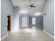 Spacious living room with light gray walls, high ceilings, ceiling fan, and light wood-look flooring at 9362 Helmsdale Dr, Indianapolis, IN 46256