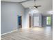 Spacious living room with light gray walls, high ceilings, ceiling fan, and light wood-look flooring at 9362 Helmsdale Dr, Indianapolis, IN 46256