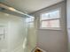 Bright shower with glass doors, tiled floor and view of exterior at 9362 Helmsdale Dr, Indianapolis, IN 46256