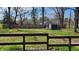 Fenced-in backyard with a lush lawn, mature trees, and a wooden shed, viewed from the wooden deck at 9882 Woodbriar Ln, Carmel, IN 46280
