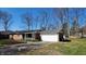 Charming brick ranch home featuring an attached two-car garage and cozy front porch at 9882 Woodbriar Ln, Carmel, IN 46280
