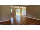 Open-concept living room featuring gleaming hardwood floors and a glass patio door to the backyard at 9882 Woodbriar Ln, Carmel, IN 46280
