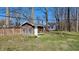 Wooden shed in a fenced backyard with daffodil landscaping and mature trees at 9882 Woodbriar Ln, Carmel, IN 46280
