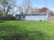 Spacious backyard featuring a grassy lawn and a charming blue home with a sliding glass door at 99 Armitage St, Cicero, IN 46034