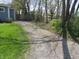 Gravel driveway to the side of the property with trees surrounding at 99 Armitage St, Cicero, IN 46034