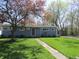 Classic single-story home with a blue exterior, a well-manicured lawn, and mature trees at 99 Armitage St, Cicero, IN 46034