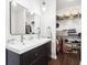 Modern bathroom featuring dual sinks, a framed mirror, and closet at 1015 Villa Ave, Indianapolis, IN 46203