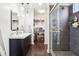 Stylish bathroom featuring dual sinks, a walk-in shower with glass door, and organized closet at 1015 Villa Ave, Indianapolis, IN 46203