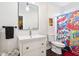 Bright bathroom featuring a white vanity, framed mirror, and fun, comic-themed shower curtain at 1015 Villa Ave, Indianapolis, IN 46203