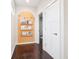 Hallway features dark wood floors and a built-in bookcase with colorful books and decorations at 1015 Villa Ave, Indianapolis, IN 46203