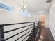 Hallway with railing, modern light fixture, and built-in bookcase with colorful books for a cozy space at 1015 Villa Ave, Indianapolis, IN 46203