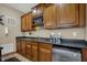 Bar area with wood cabinets, wine rack, mini fridge, and granite countertops at 10814 Tallow Wood Ln, Indianapolis, IN 46236
